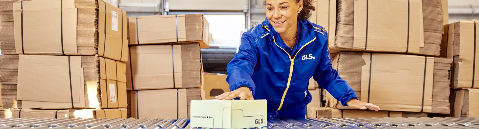 Mitarbeiterin im Depot mit Paket