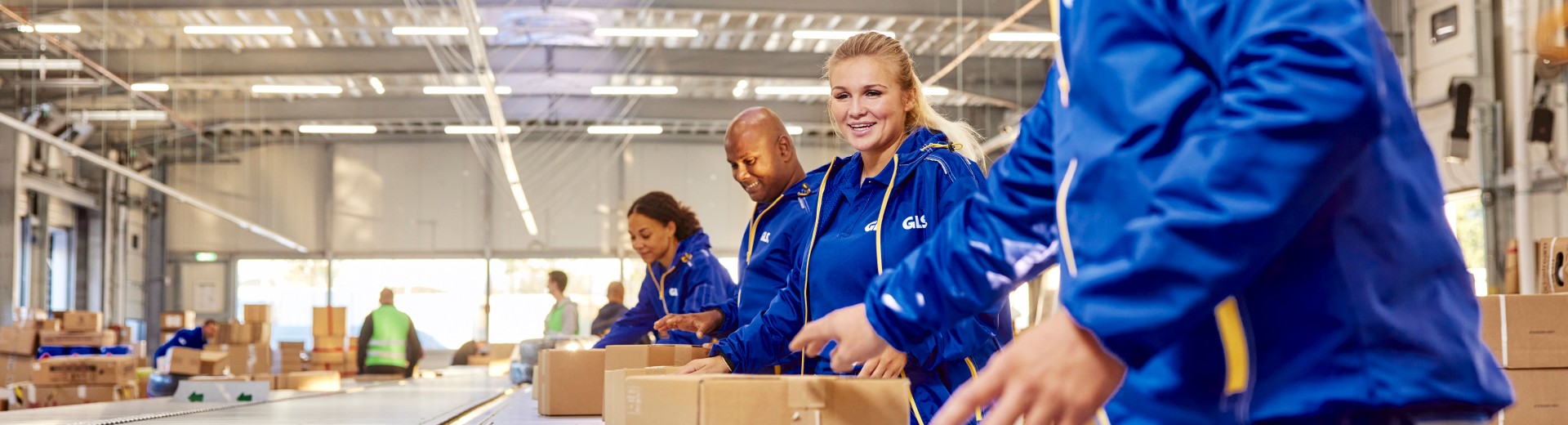 GLS employees working together by the parcel conveyor belt.