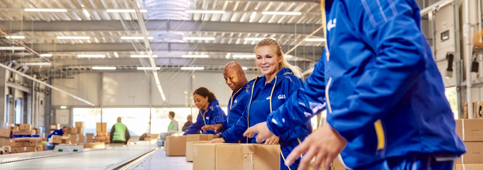 GLS employees working together by the parcel conveyor belt.