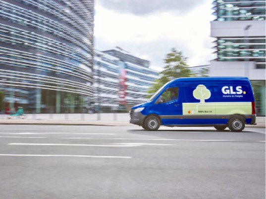 GLS delivery van driving in an urban area, illustrating the group’s environmental commitments and sustainable transport initiatives.