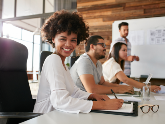 Employee taking notes during a corporate training session with colleagues, illustrating disability support, workplace inclusion and skills development at GLS.