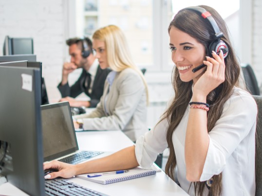 Customer service agent smiling with a headset.