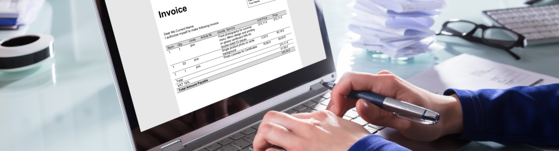 Hands typing on a keyboard with a GLS invoice on the screen